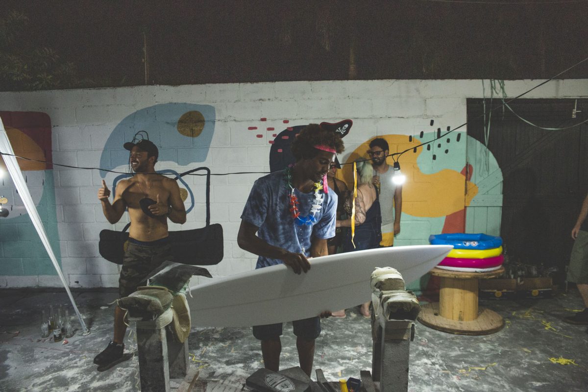 Surfista Victor Bernardo olha prancha de surf com Caio Ibelli