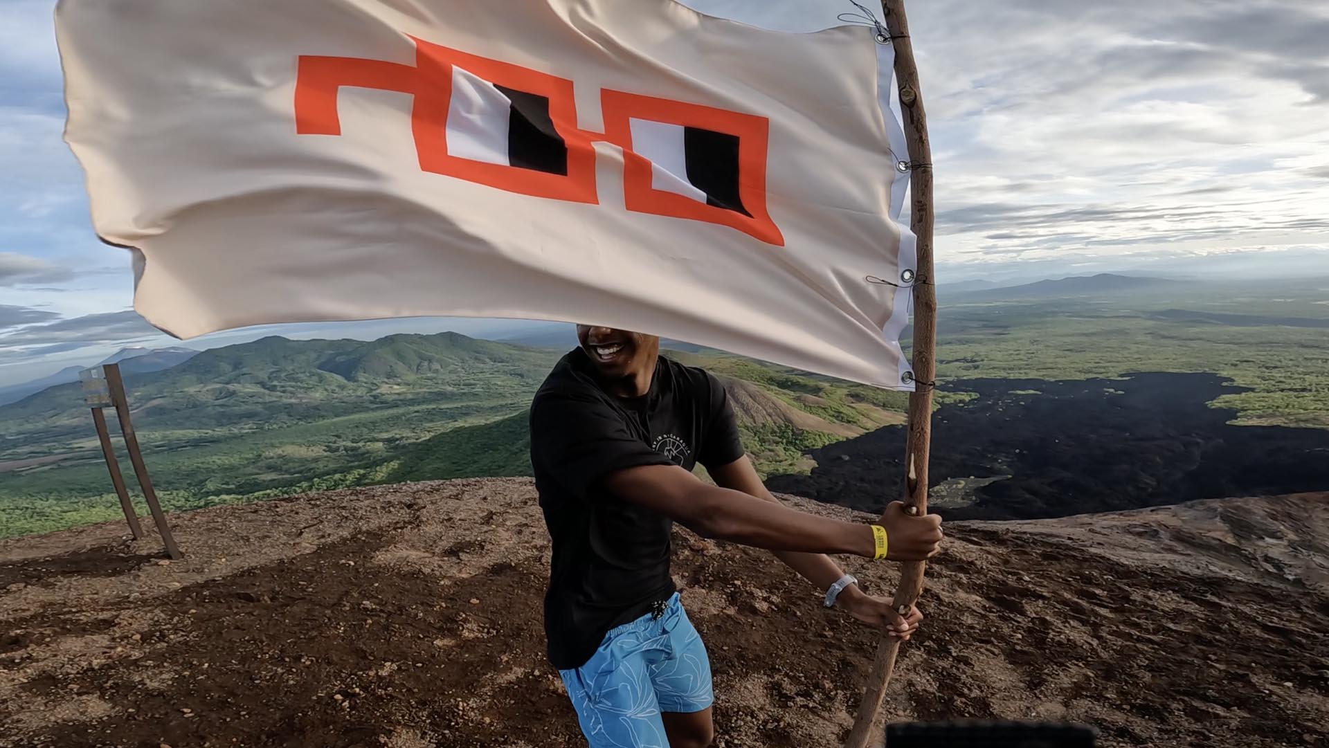 Sunny Pires com bandeira da Nouns em vulcão da Nicarágua